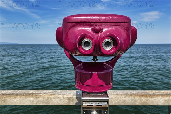Red telescope on pier, coin telescope points to water, sunny weather, Binz seaside resort, Rügen,