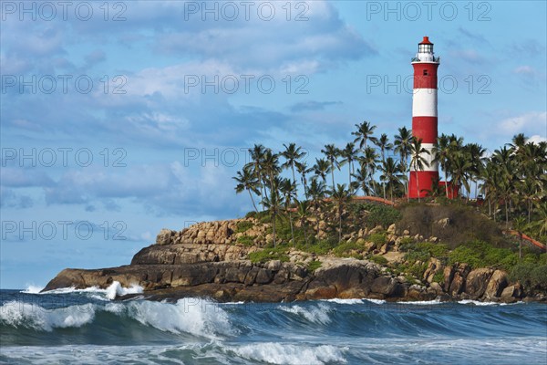 Lighthouse on rocky cliff and sea with waves