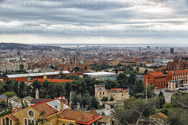 View of the sea of houses up to the coast, cloudy sky in autumn, haze, Tibidabo, Barcelona, Spain,