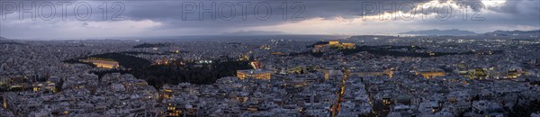 Panorama, view over the sea of houses of Athens, illuminated Parthenon temple on the Acropolis,