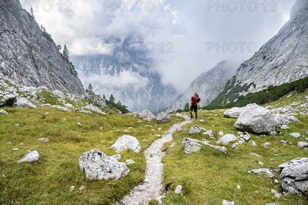 Mountaineer on a hiking trail, cloudy mountains, descent over the Ofental, mountain tour on the