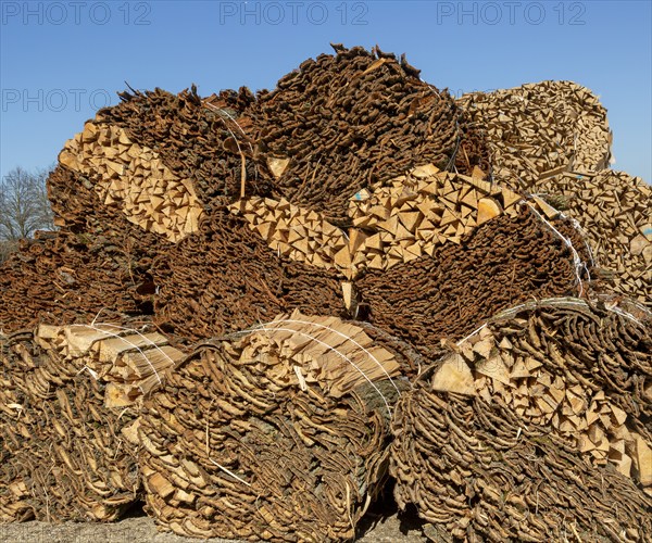 Bundles of wood offcuts and bark at a willow sawmill, Suffolk, England, UK