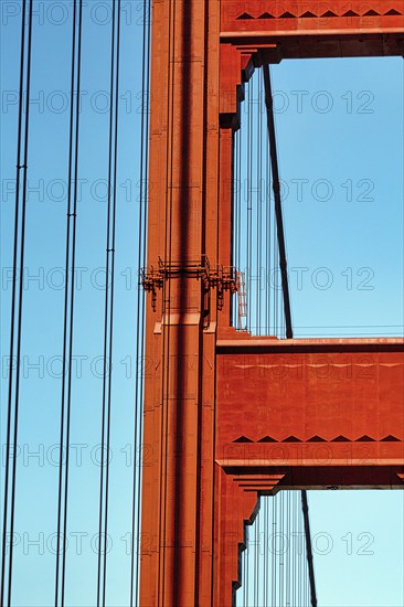 Orange pylon and steel cables of the suspension bridge, detail, Golden Gate Bridge, blue sky, San
