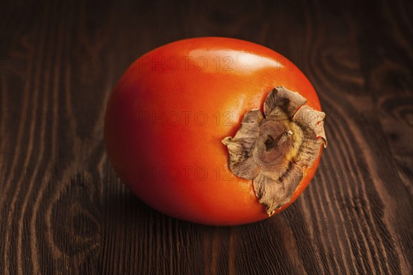 Fresh ripe persimmon on a wooden background