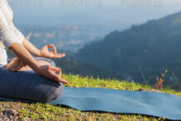Meditation relaxation concept background, close up of woman in Padmasana yoga lotus pose with chin