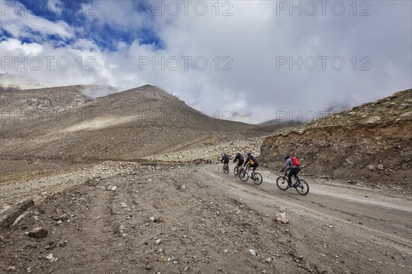 KARDUNG LA PASS, INDIA, SEPTEMBER 5, 2011: Bicycle tourists in Himalayas asceinding to Khardung La