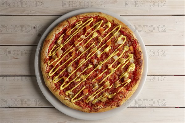 Top view of pizza with sun-dried tomatoes and mustard sauce