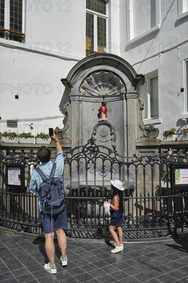 BRUSSELS, BELGIUM, MAY 31, 2018: Tourist taking pictures in front of famous tourist attraction of