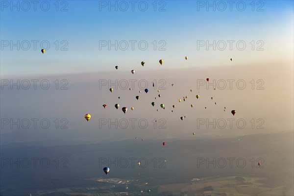 Many different hot air balloons on the way in the blue sky, distance, hot air balloon festival,
