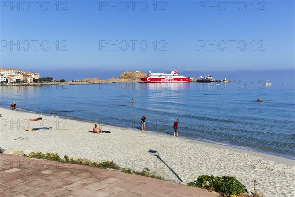 Tourists on the sandy beach, view of ferry in the harbour, L'Île-Rousse, Ile Rousse, Corsica,