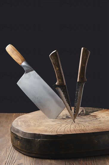 Cleaver and knives stick in wooden stump