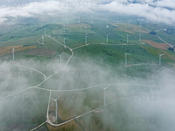 Windmills on a wind farm near Zahara de los Atunes, at a cloudy morning, aerial view, drone shot,
