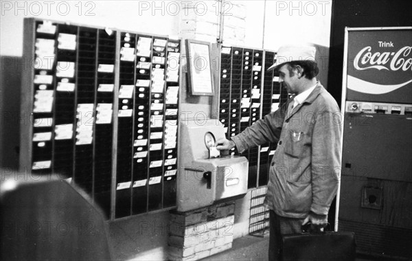 Workers and employees at the time clock of the Pohlschroeder company in Dortmund, Germany, on 01.08