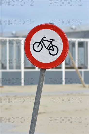 Red bicycle street warning sign on shore of Texel