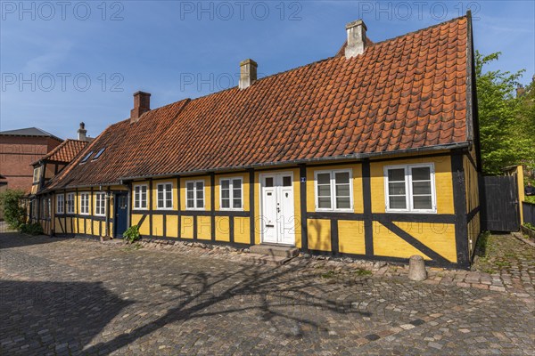Svendborg Old Town, yellow half-timbered house, door, red roof tiles, chimneys, cobblestones, Fyn,