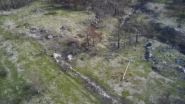 Drone image, above Kiotari, Vast barren landscape with remains of burnt trees and boulders after a