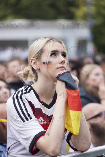 A woman watches the football match in the fan zone at the Brandenburg Tor during the quarter-final