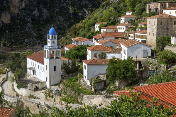 View over houses and rooftops to Greek Orthodox Church of Saint Spyridon, village of Dhermi,