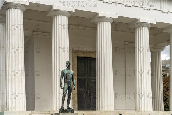 Statue of a young athlete and the Theseus Temple in the Volksgarten Vienna, Austria, Europe