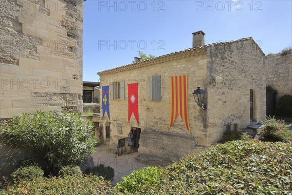 Building with banner and flags, mountain village, Les Baux-de-Provence, Alpilles, Alpilles,