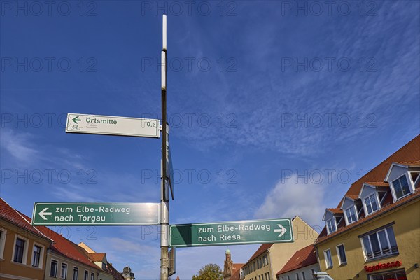 Signpost to the Elbe cycle path to Torgau and Riesa against a blue sky with cirrostratus clouds,