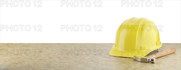 Yellow construction hard hat and hammer resting on particleboard banner isolated on a white