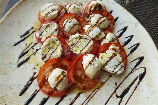 Italian cuisine, Insalata Caprese, vine tomatoes, buffalo mozza arranged on a plate, balsamic