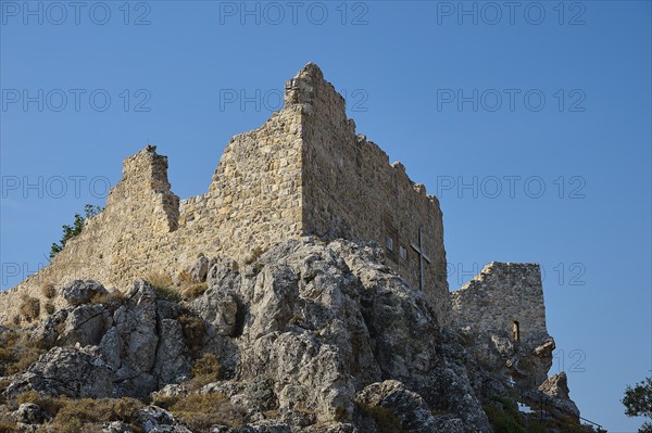 Stony ruins of an ancient tower on a rock under a clear blue sky, St John's Castle, Archengelos