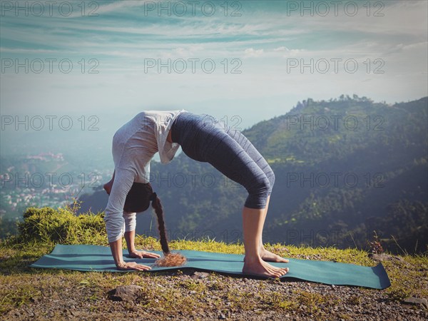 Yoga outdoors, young sporty fit woman doing Ashtanga Vinyasa Yoga asana Urdhva Dhanurasana, upward