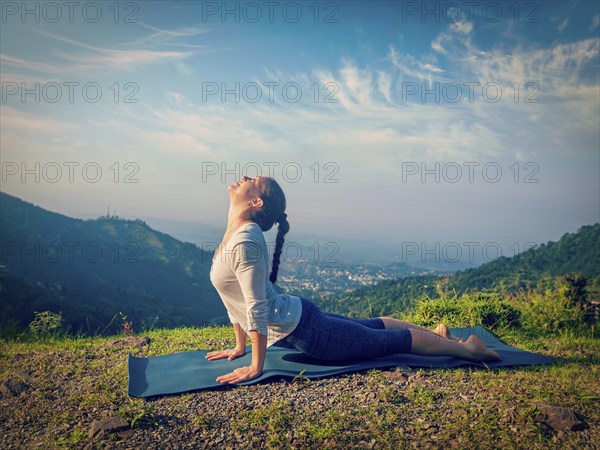 Yoga outdoors, woman practices Ashtanga Vinyasa yoga Surya Namaskar Sun Salutation asana Urdhva