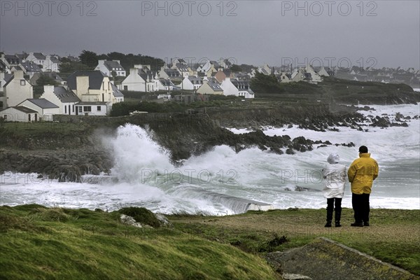 Tourists looking at winter storm at sea at Pors Poulhan, Plouhinec, Morbihan, Brittany, France,