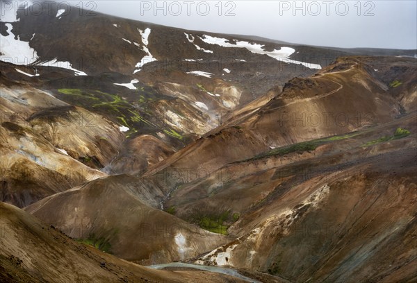 Steaming streams between colourful rhyolite mountains in the Hveradalir geothermal area,