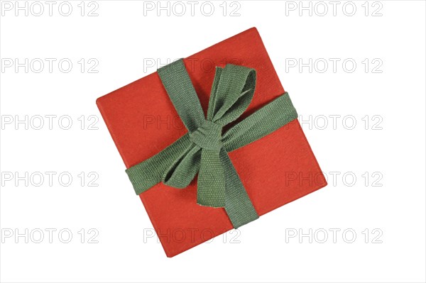 Top view of red Christmas gift box with green ribbon on white background