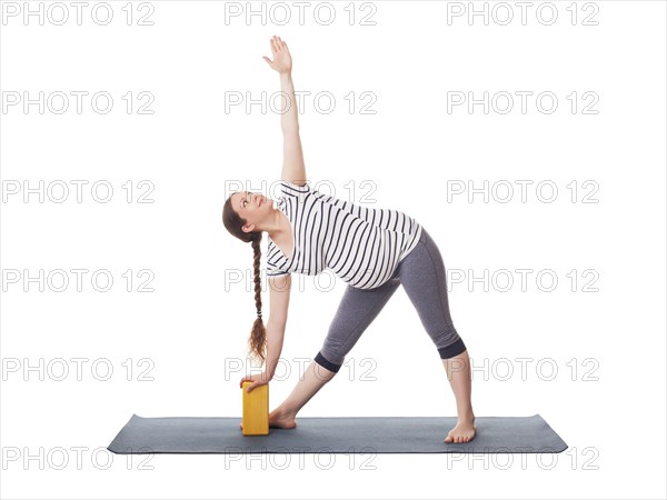 Pregnancy yoga exercise, pregnant woman doing asana Utthita trikonasana, extended triangle pose