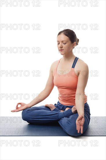 Beautiful fit yogini woman meditating in yoga asana Padmasana (Lotus pose) cross legged position