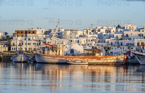 View of Naoussa, Fishing boats in the harbour at sunset, reflected in the sea, White Cycladic