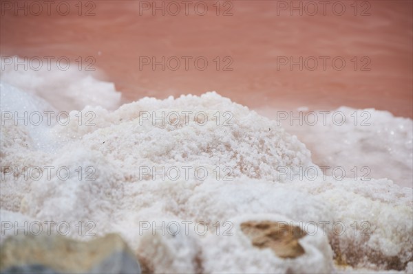 Salt crust at the waters edge of a little salt water pond for industrial salt production,