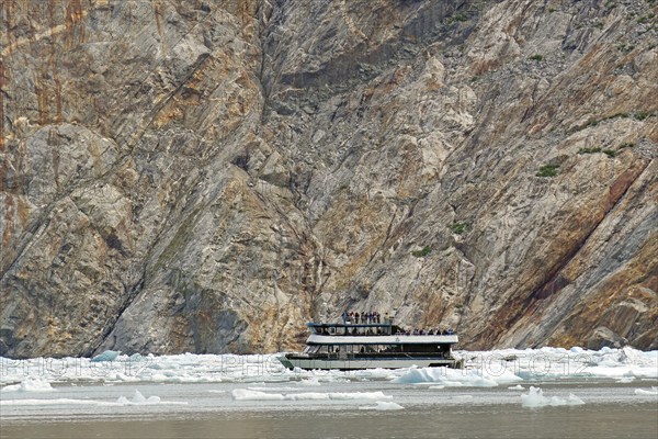 Small boat between ice of a glacier calving into the sea, Tracy Arm Fiord, Tongass National Forest,
