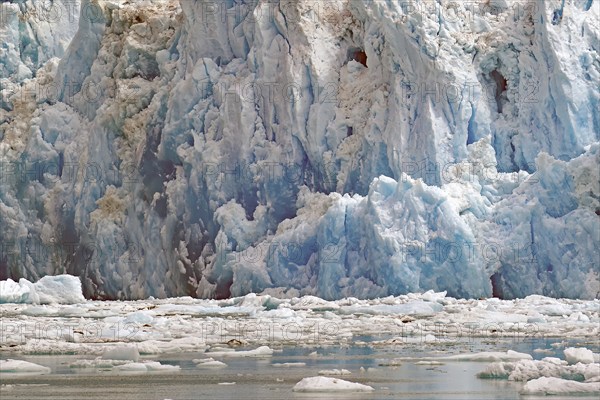 Ice of a glacier calving into the sea shimmers bluish, Tracy Arm Fiord, Tongass National Forest,