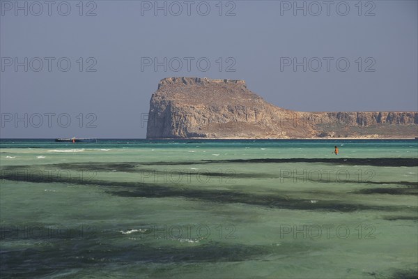 Lagoon, green sea, ship, tourist in the water, Venetian sea fortress Gramvoussa, peninsula