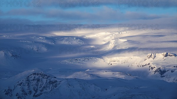 Light and shadow over the snowy hills and mountains of Myrdalsjökull, Sudurland, Iceland, Europe