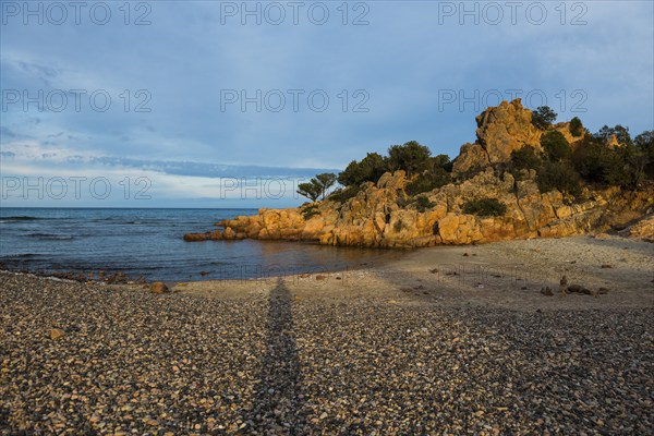 Lonely picturesque beach and red rocks, Spiaggia Su Sirboni, sunset, near Tertenia, Province of