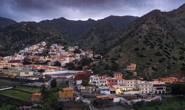 View of Vallehermoso and the surrounding mountain landscape in the evening under a cloudy sky.