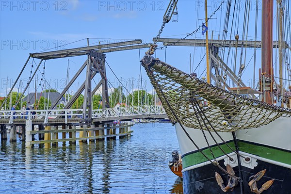 Bowsprit and bow of a sailing ship against the picturesque backdrop of Greifswald Wieck town