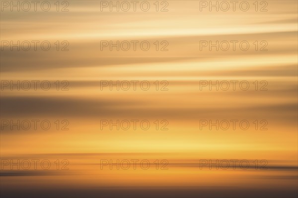 Orange-coloured evening sky with clouds near Lüneburg shortly after sunset, wiping effect, Lower