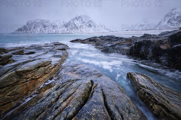 Waves and rocks on coast of Norwegian sea in fjord. Skagsanden beach, Flakstad, Lofoten islands,