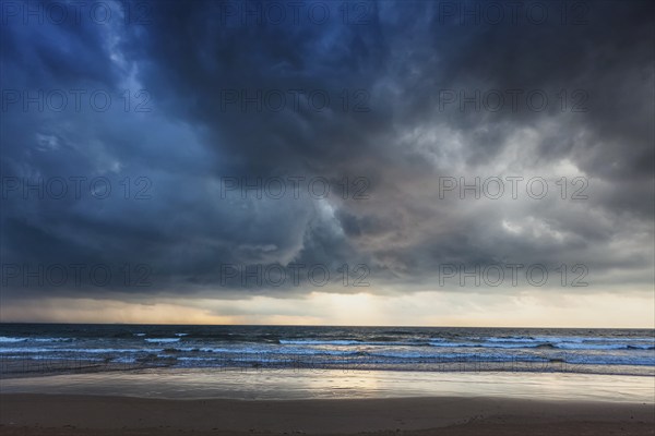 Gathering storm on beach with dark clouds. Baga, Goa, India, Asia
