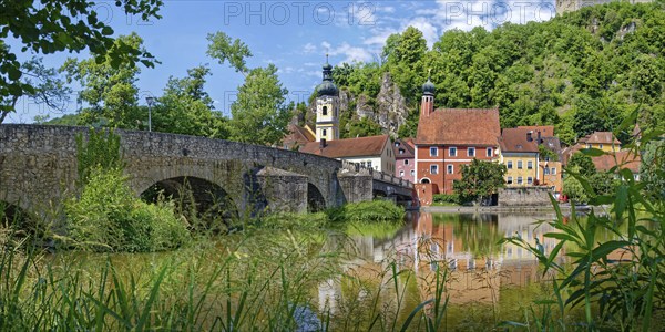 Panoramic view of the ancient stone bridge over the river Naab with the church tower of St Michael