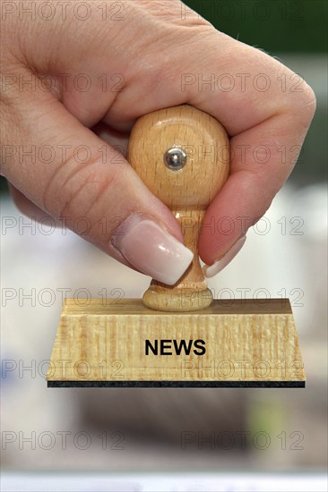 Symbol photo, woman's hand with stamp, inscription: News, Studio