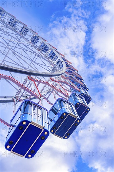 View upwards to a Ferris wheel in front of a clear blue sky, Stuttgart, Germany, Europe